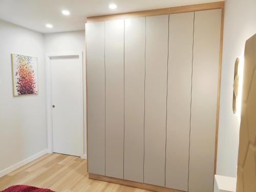 a large white wardrobe in a room with a door at Apartamentos Centro Oviedo Caveda in Oviedo