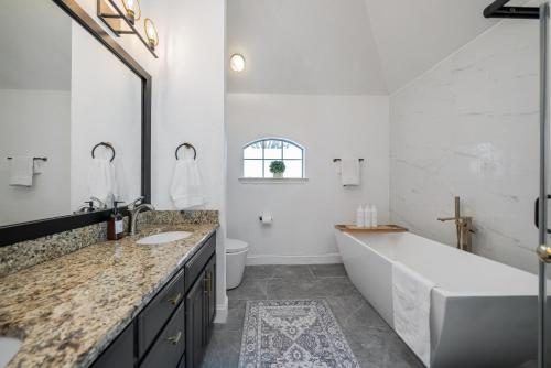 ein Badezimmer mit einer großen Badewanne und einem Waschbecken in der Unterkunft The Lido House, Cozy Family-Friendly Retreat in Frisco