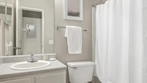 een witte badkamer met een toilet en een wastafel bij Landing - Modern Apartment with Amazing Amenities (ID1182X728) in College Park