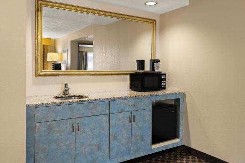 a bathroom with a sink and a mirror at Hotel RL Cleveland Airport West in North Olmsted