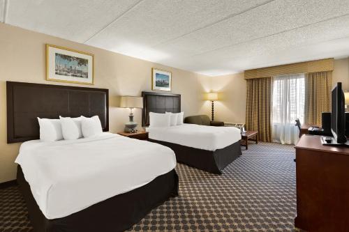 um quarto de hotel com duas camas e uma televisão em Hotel RL Cleveland Airport West em North Olmsted