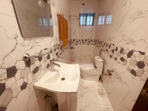 een witte badkamer met een wastafel en een toilet bij Britannia House near Islamabad International Airport and Motorway in Islamabad