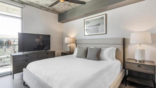 sypialnia z białym łóżkiem i telewizorem w obiekcie Landing - Modern Apartment with Amazing Amenities (ID7458X47) w mieście Tucson