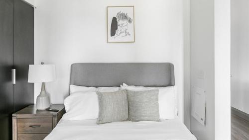 1 dormitorio con 1 cama con sábanas y almohadas blancas en Landing - Modern Apartment with Amazing Amenities (ID1381X632), en The Colony