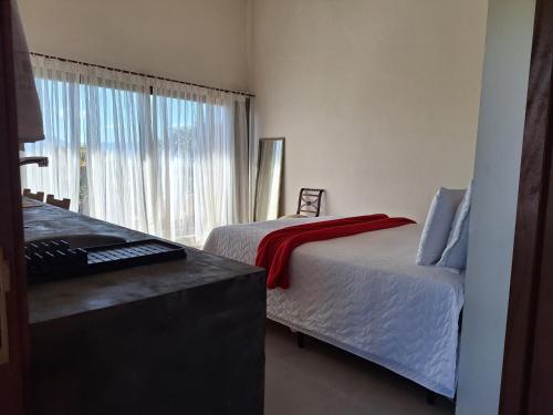 een hotelkamer met 2 bedden en een raam bij Hospedaria Noite Lunar in Praia do Rosa