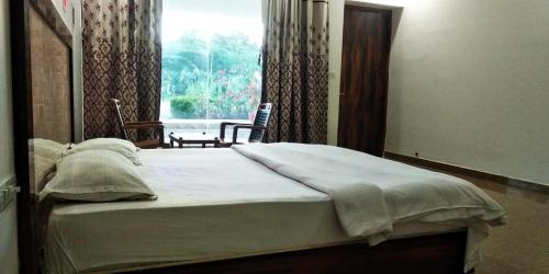 a bedroom with a large bed with a window at Hotel Radha Rani Mahal in Khajurāho