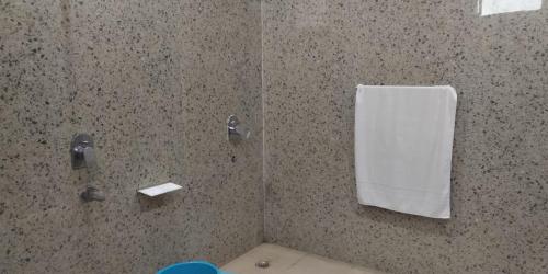 bagno con doccia e asciugamano bianco di Hotel Radha Rani Mahal a Khajurāho