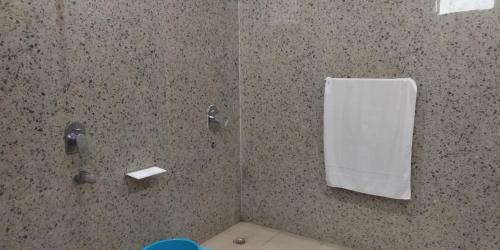 een badkamer met een douche en een witte handdoek bij Hotel Radha Rani Mahal in Khajurāho