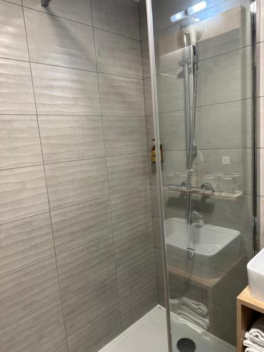 a shower with a glass door in a bathroom at Ostal Pau Universite - Sure Hotel Collection by Best Western in Pau