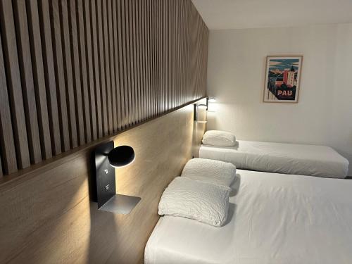a hotel room with two beds and a window at Ostal Pau Universite - Sure Hotel Collection by Best Western in Pau