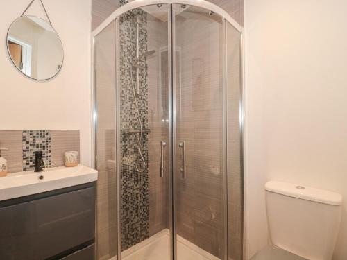 um chuveiro com uma porta de vidro na casa de banho em Piglet Corner em Culmstock