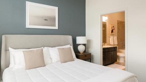 1 dormitorio con cama blanca y baño en Landing - Modern Apartment with Amazing Amenities (ID6950X30), en Houston