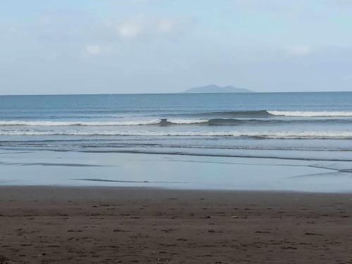 an empty beach with waves in the ocean at Purple Guesthouse in Nasugbu