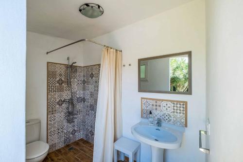 bagno con lavandino, servizi igienici e specchio di Villa Alaris a Santo Tomás
