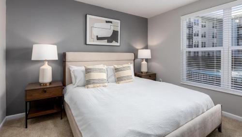 a bedroom with a bed with two lamps and a window at Landing - Modern Apartment with Amazing Amenities (ID8193X50) in Columbus