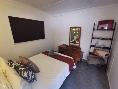 1 dormitorio con cama, espejo y TV en Feather Rest en Bloemfontein