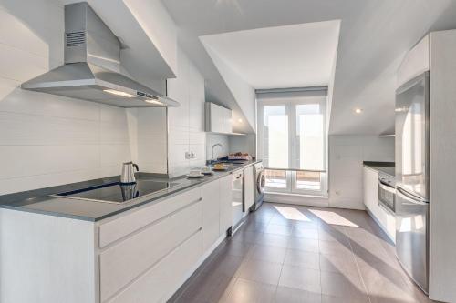 a large white kitchen with a sink and a stove at Apartamentos La Albarca in Hoznayo