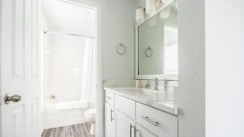 a white bathroom with a sink and a mirror at Landing - Modern Apartment with Amazing Amenities (ID6183X04) in Orlando