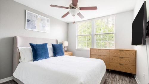 奧蘭多的住宿－Landing - Modern Apartment with Amazing Amenities (ID6183X04)，一间卧室配有一张带蓝色枕头的床和吊扇