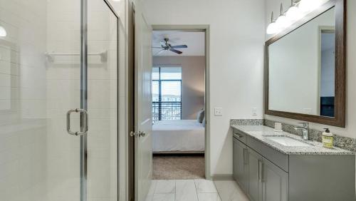 a bathroom with a shower and a sink and a mirror at Landing - Modern Apartment with Amazing Amenities (ID8403X71) in Garland