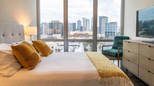 - une chambre avec un grand lit et une grande fenêtre dans l'établissement Landing - Modern Apartment with Amazing Amenities (ID1513X37), à Dallas
