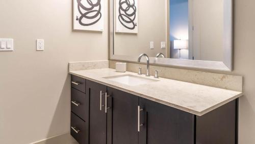 La salle de bains est pourvue d'un lavabo et d'un miroir. dans l'établissement Landing - Modern Apartment with Amazing Amenities (ID1513X37), à Dallas