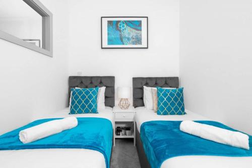 dwa łóżka w pokoju niebiesko-białym w obiekcie Modern Apartment - Twin Beds - Free Netflix & Wifi - Parking - Top Rated - 7OC w mieście Brierley Hill