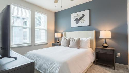 a bedroom with a white bed and two windows at Landing - Modern Apartment with Amazing Amenities (ID8375X72) in Middleburg