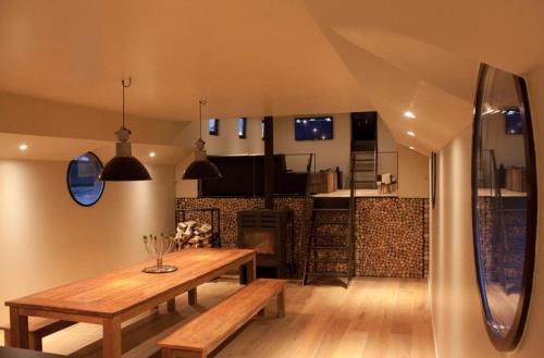 a dining room with a wooden table and a kitchen at Bed in Boat in Ypres