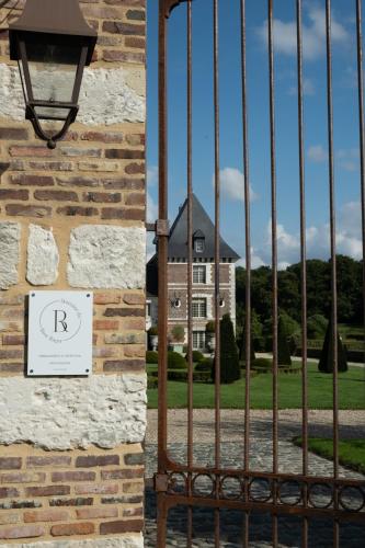 une porte en face d'un bâtiment avec une maison dans l'établissement Domaine du Bosc Roger, à Bouquetot