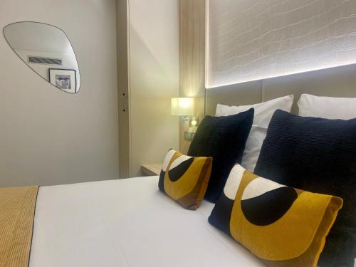Schlafzimmer mit einem Bett mit blauen und gelben Kissen in der Unterkunft Kyriad Beaune in Beaune