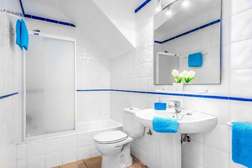 a white bathroom with a toilet and a sink at Villa Cati Punta Prima in Punta Prima