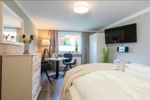 a bedroom with a bed and a desk and a table at Haus Schwanensee, Wohnung 9 in Bosau