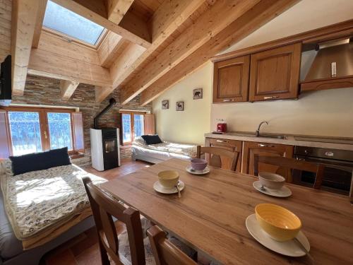 una cucina e una sala da pranzo con tavolo in legno in una cabina di Affittimoderni Ponte di Legno Ski a Ponte di Legno