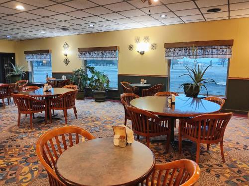 una sala da pranzo con tavoli, sedie e finestre di The Lodge at Russell - Russell Inn a Russell