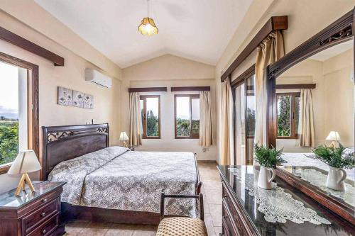 a bedroom with a large bed and windows at Villa Irene Polis in Polis Chrysochous
