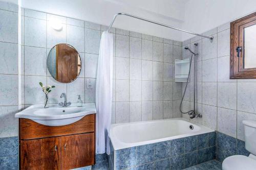 a bathroom with a tub and a sink and a toilet at Villa Irene Polis in Polis Chrysochous