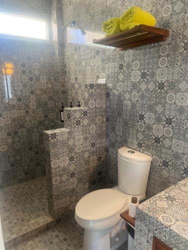 a bathroom with a white toilet and a sink at Buda Blanca 5 min caminando a la playa in Cuatunalco