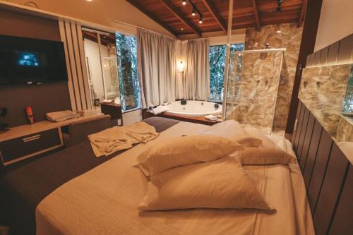 ein Schlafzimmer mit einem Bett und einer Badewanne in einem Zimmer in der Unterkunft Paraíso do Salto in Lages