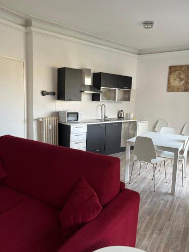 a living room with a red couch and a kitchen at St Peter Lodge in Rome