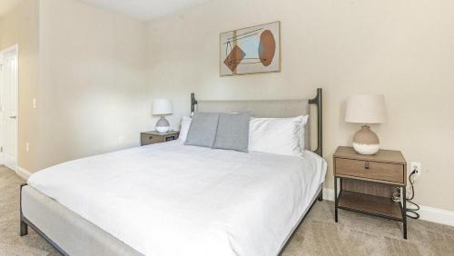 a bedroom with a large white bed with two night stands at Landing - Modern Apartment with Amazing Amenities (ID1285X345) in Greensboro