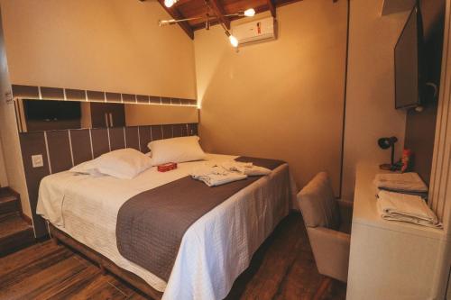 a bedroom with a bed with two towels on it at Paraíso do Salto in Lages