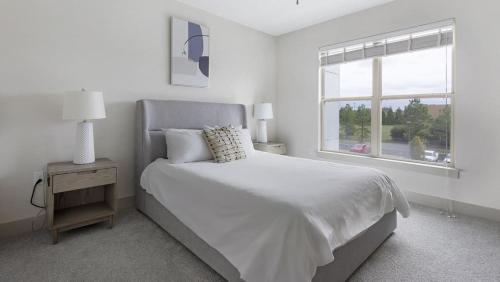 a white bedroom with a bed and a window at Landing - Modern Apartment with Amazing Amenities (ID5286X10) in Richmond