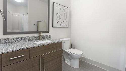 a bathroom with a toilet and a sink and a mirror at Landing - Modern Apartment with Amazing Amenities (ID5286X10) in Richmond
