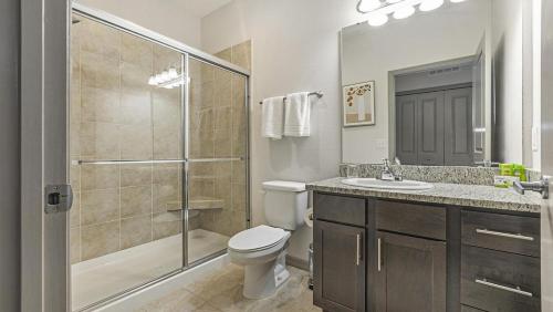 y baño con ducha, aseo y lavamanos. en Landing - Modern Apartment with Amazing Amenities (ID3425X37), en Bradenton