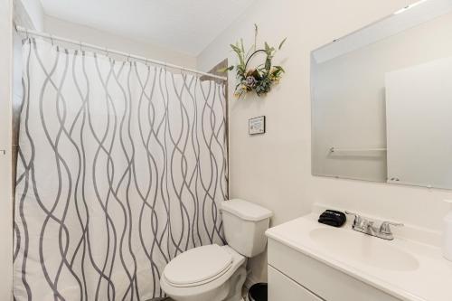 a bathroom with a toilet and a shower curtain at Stylish 2 Bedroom Apartment In The Heart Of Miami in Miami