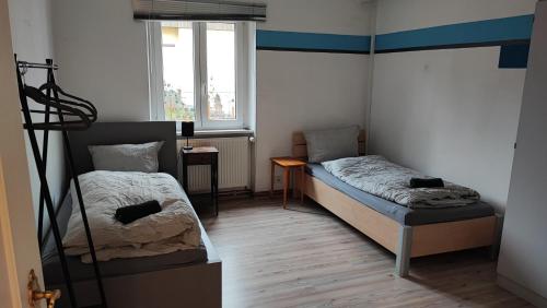 a small room with two beds and a window at Monteurwohnung bis 6 Personen mit 4 gratis Parklätzen und Grill und WLAN 3x Schlafzimmer in Veitshöchheim
