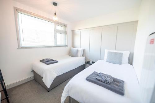 a bedroom with two beds and a window at Find peace in a chalet by the beach in Kessingland