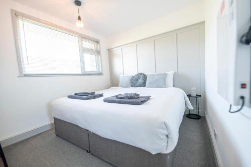 a bedroom with a large white bed with towels on it at Find peace in a chalet by the beach in Kessingland