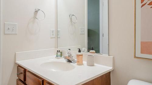 bagno con lavandino bianco e specchio di Landing - Modern Apartment with Amazing Amenities (ID7689X22) a Spring Hill